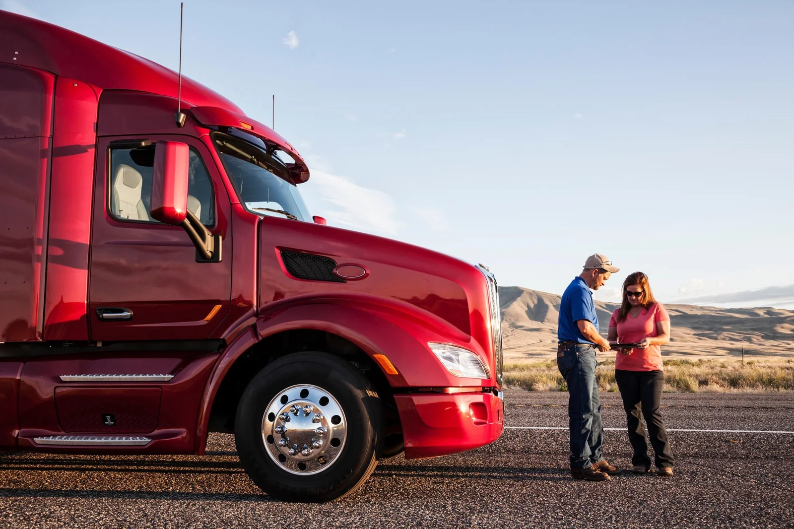 Commercial driver and colleague reviewing information beside a truck