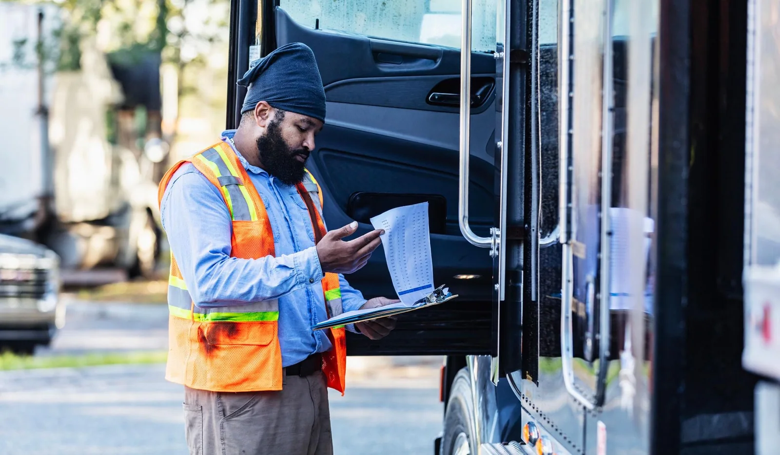 Commercial driver reviewing license paperwork beside a truck