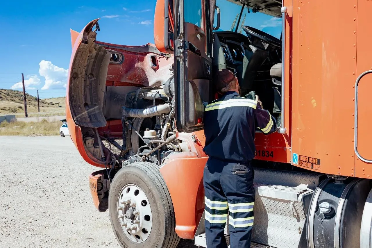 Truck professional inspecting an orange commercial truck