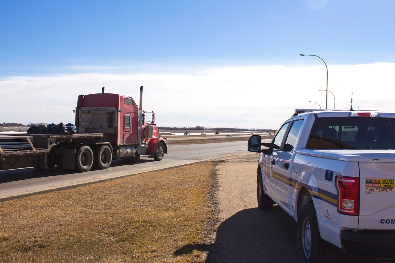 Commercial truck stopped beside a roadside enforcement vehicle