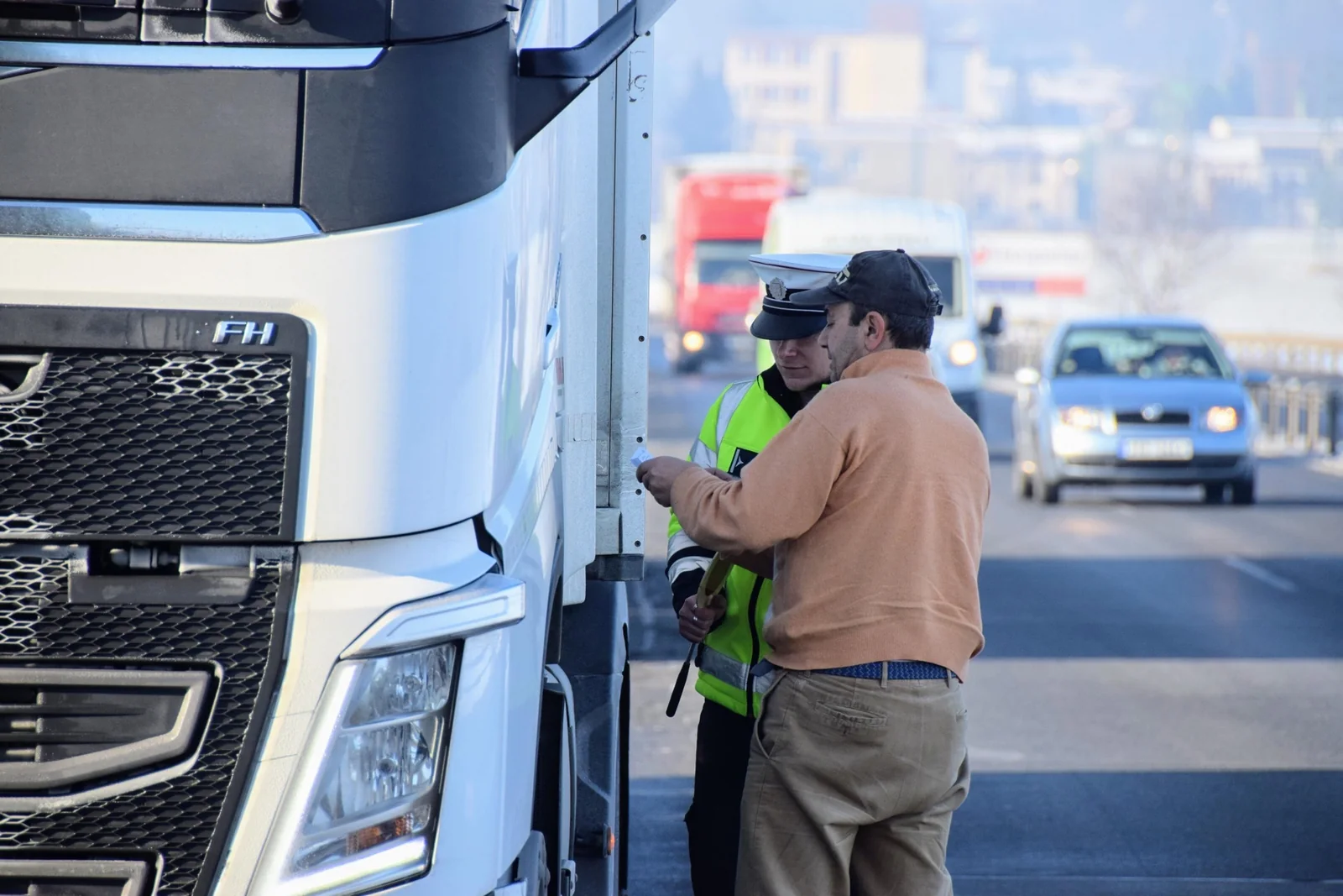 Traffic officer reviewing a citation with a commercial truck driver at the roadside